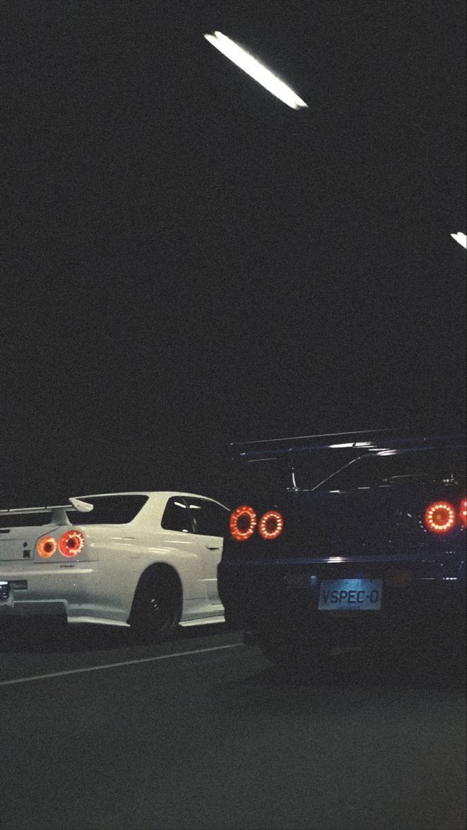 two cars parked next to each other in the dark