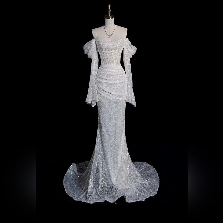 a white wedding dress on display in the dark