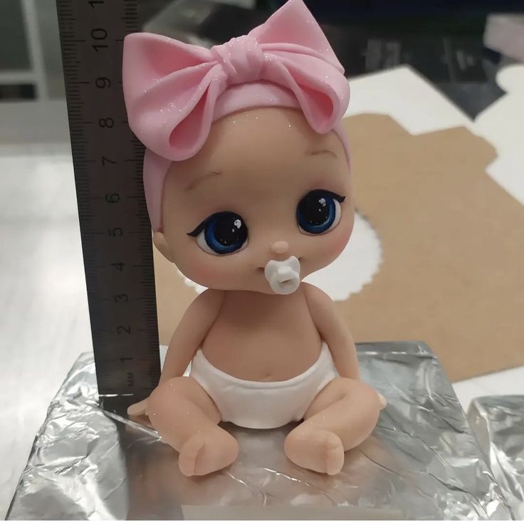 a baby doll with a pacifier sitting on top of a piece of tin foil