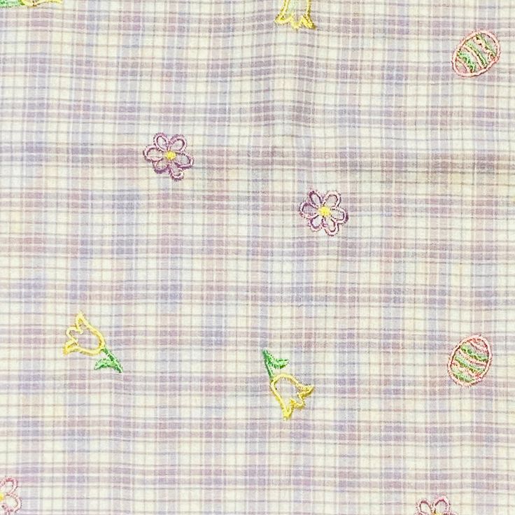 the fabric has flowers on it and is light purple with green, yellow and pink