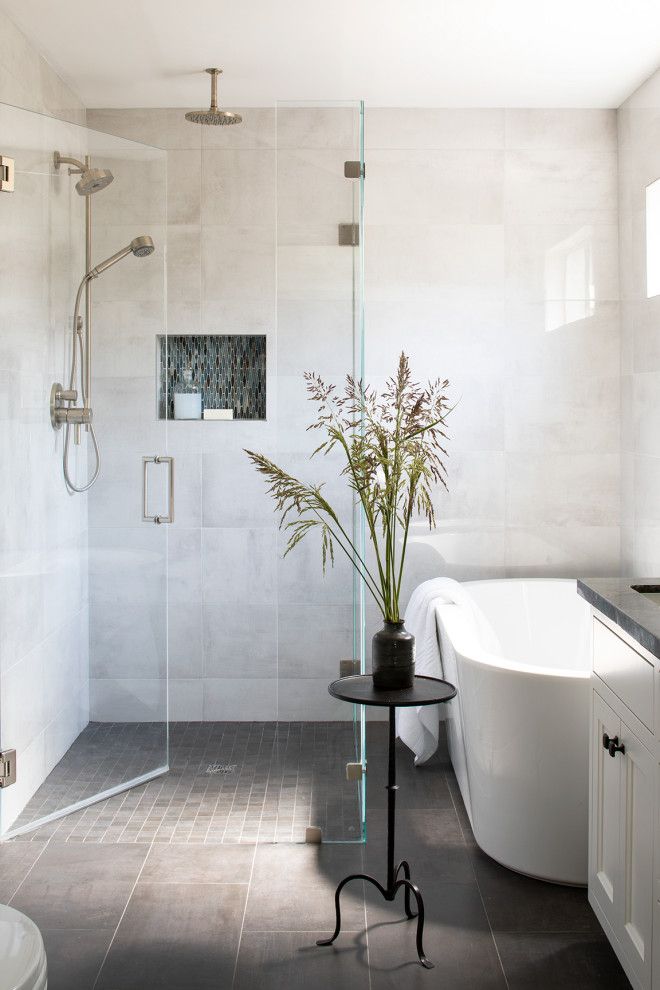 a white bath tub sitting next to a walk in shower