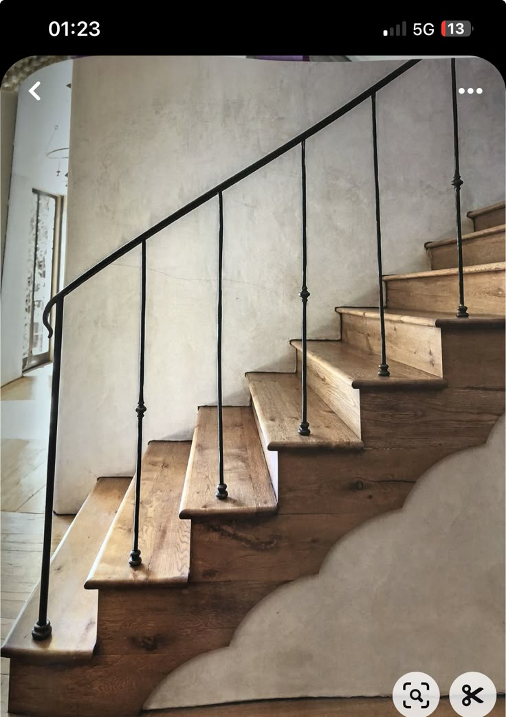 a wooden stair case with metal handrails on the bottom, and wood tread