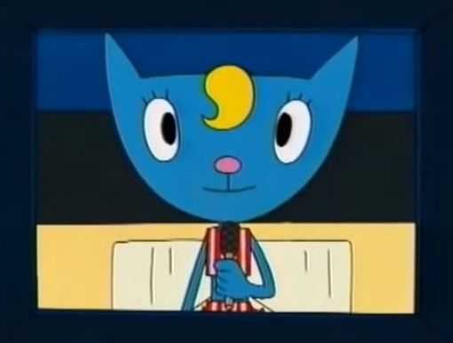 the blue cat is holding a red object in its hand and looking at it's reflection