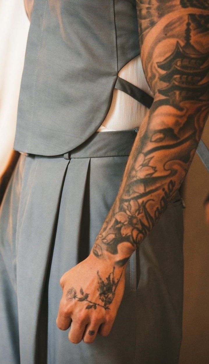 a man with tattoos on his arm and hand