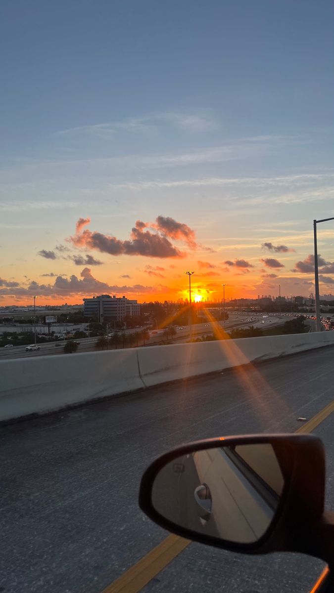 the sun is setting on an empty highway