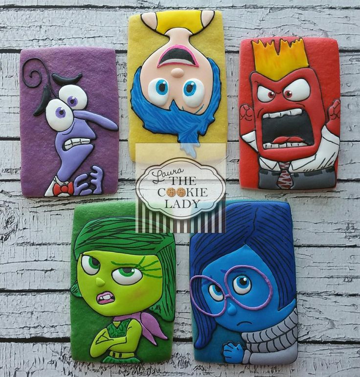 four handmade coasters with cartoon characters painted on them, all in different colors