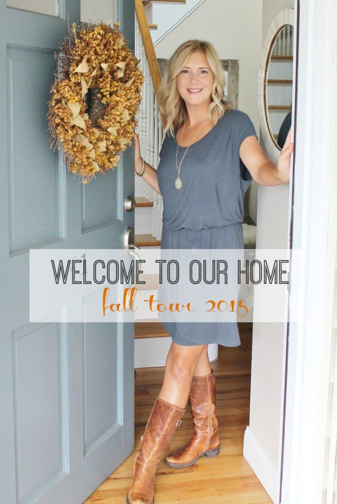 a woman standing in front of a door holding a wreath