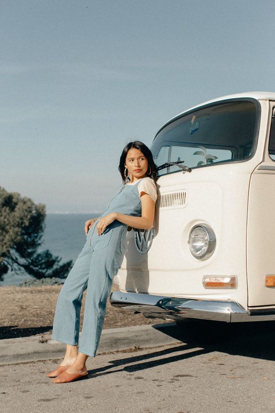 a woman standing next to a white vw bus