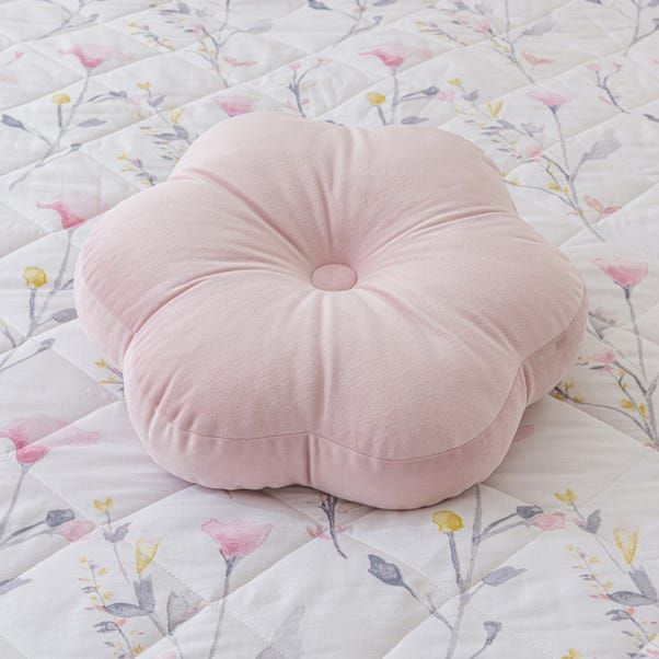 a pink pillow sitting on top of a bed