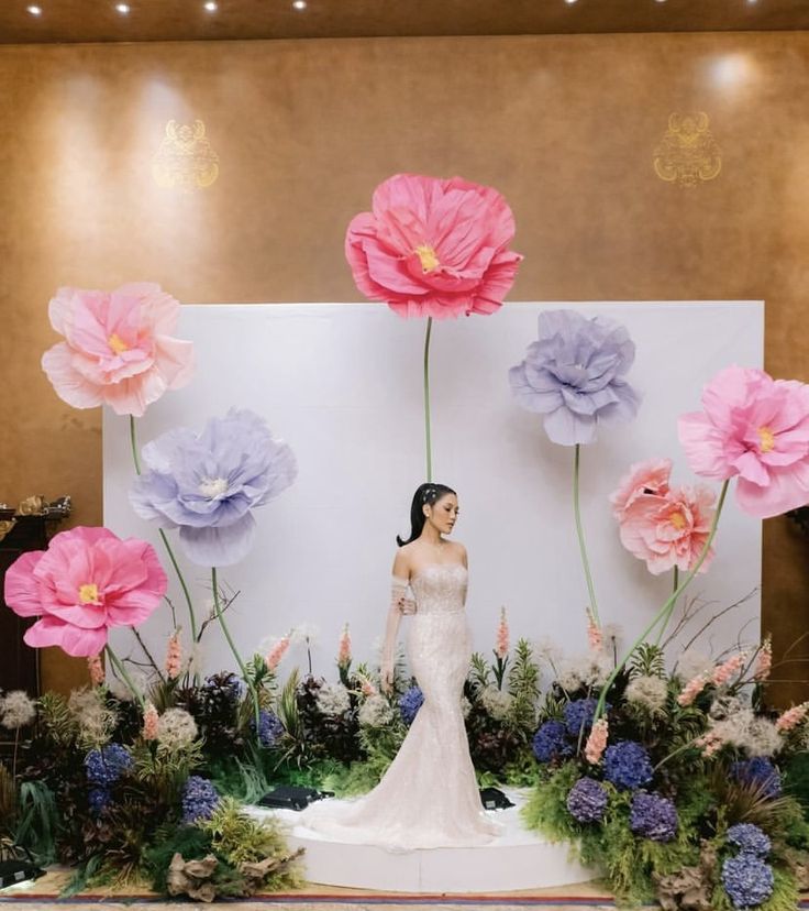 a woman standing in front of flowers on display