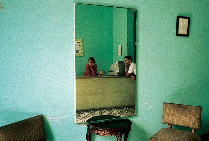 two people sitting at a counter in a room with blue walls and chairs around them