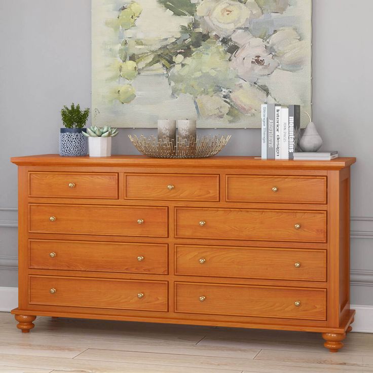 a wooden dresser sitting in front of a painting