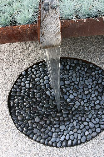 a water fountain spewing out rocks into the ground