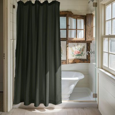 a bathroom with a tub, shower curtain and window in it's center area