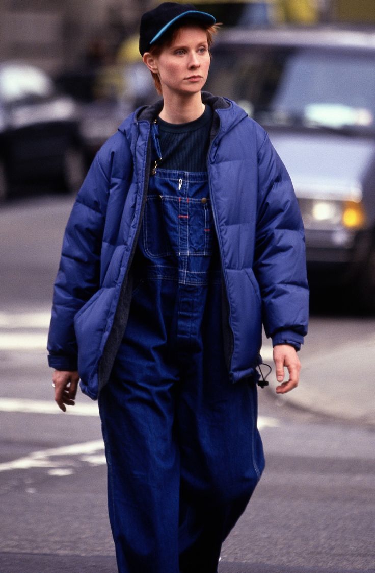 a man walking down the street in overalls