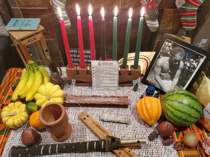 a table topped with lots of different types of fruit and vegetables next to lit candles