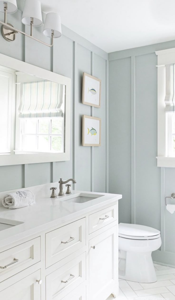 a bathroom with blue walls and white fixtures