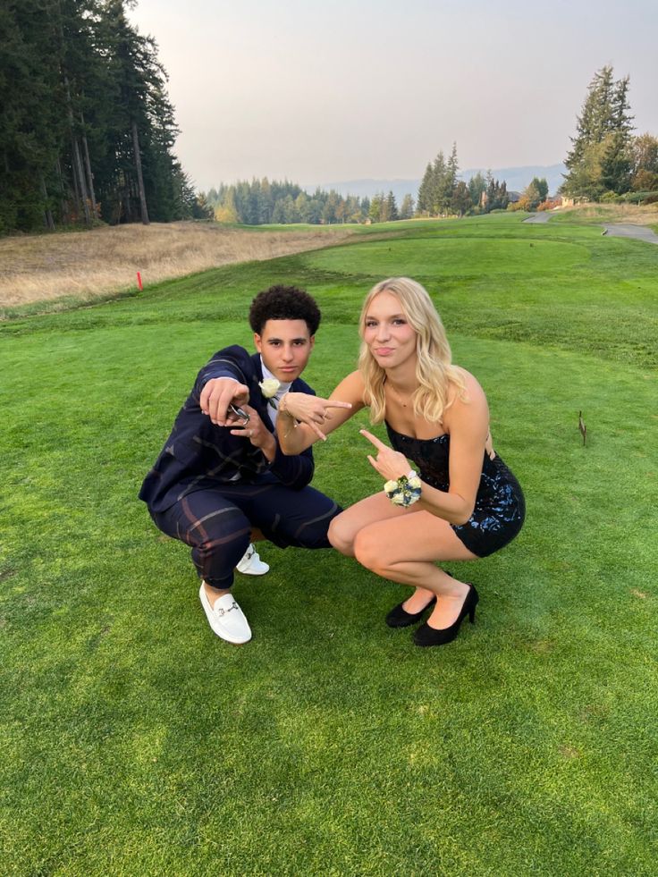 a man and woman kneeling down in the grass