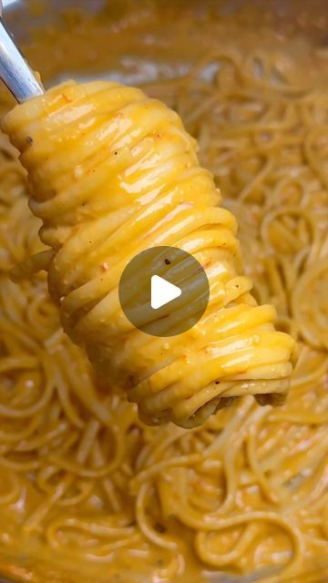 a ladle full of noodles being held up by a fork with the word pasta on it