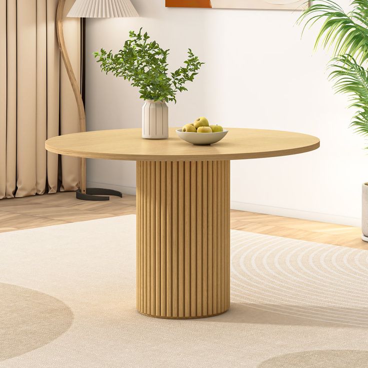 a round table with two vases on it in a room next to a potted plant