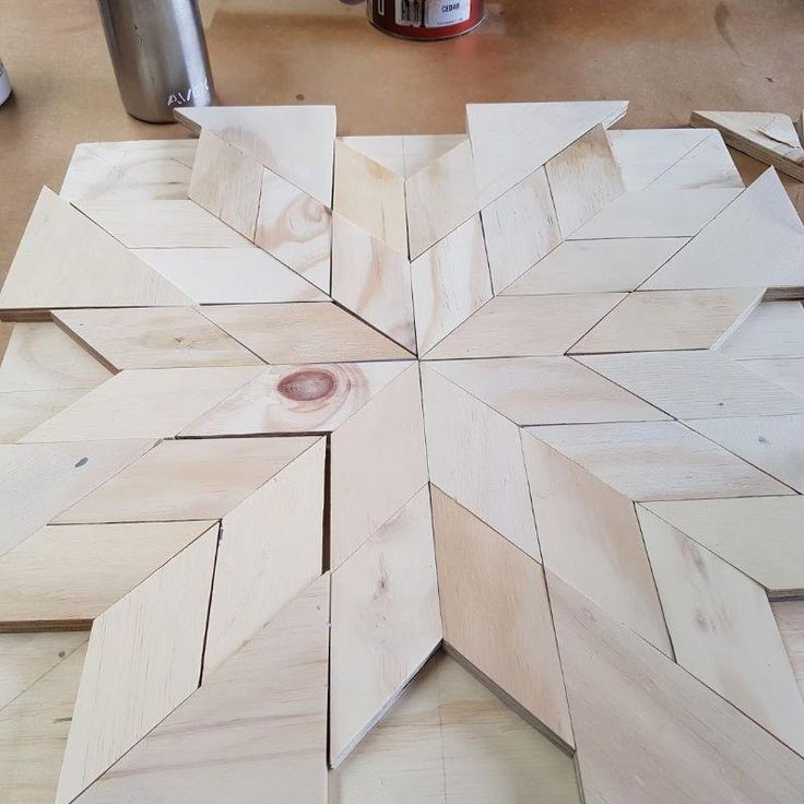 a wooden snowflake sitting on top of a table next to other woodworking supplies