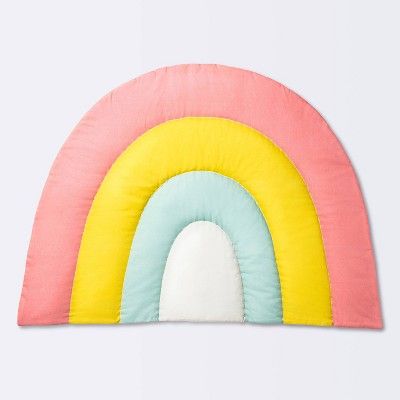 a pink, yellow and blue pillow with a rainbow on it