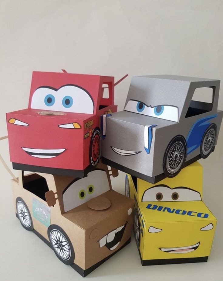 some cars are sitting on top of each other in different colors and shapes with eyes