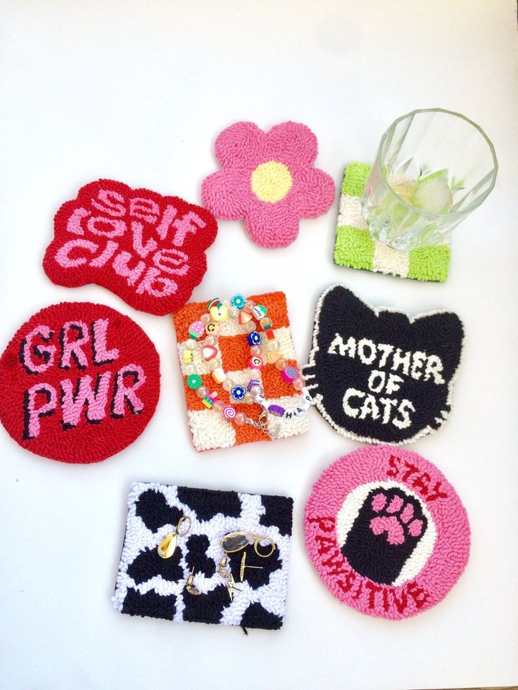 several patches with different designs on them sitting next to a vase filled with flowers and leaves