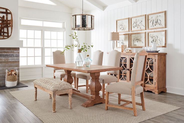 a dining room table and chairs in front of a fireplace