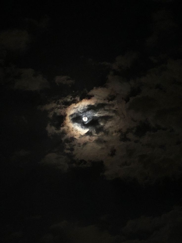 the moon is shining brightly in the dark sky with clouds around it, and there is no image to describe