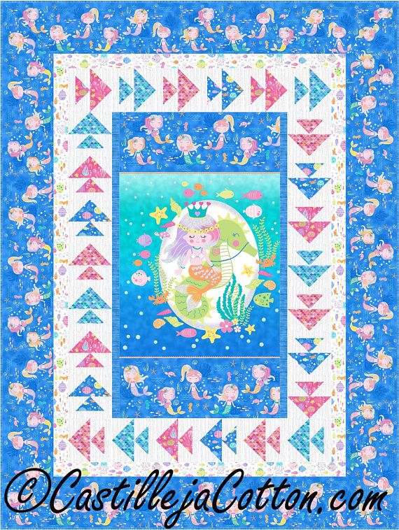 a blue quilt with mermaids and stars on it, in front of a white background