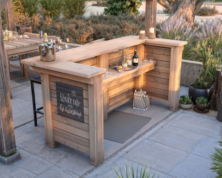 an outdoor bar with bottles and glasses on it