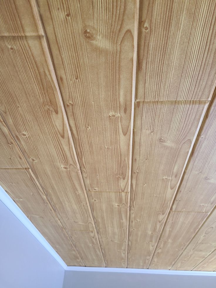 the ceiling is made of wood planks and has white paint on it's walls