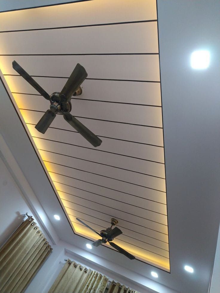 a ceiling with some lights on it and a fan hanging from the ceiling in front of two windows