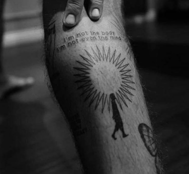 a black and white photo of a person's arm with a tattoo on it