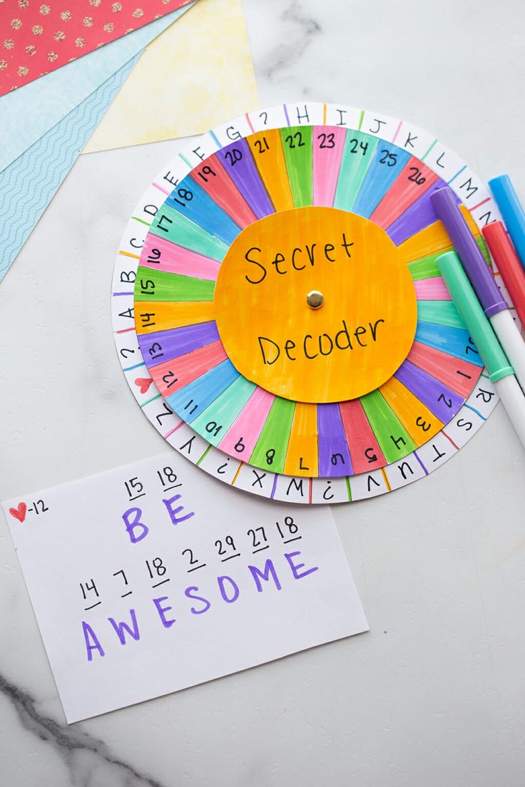 a paper plate with the word'secret decoder'written on it next to markers and pens