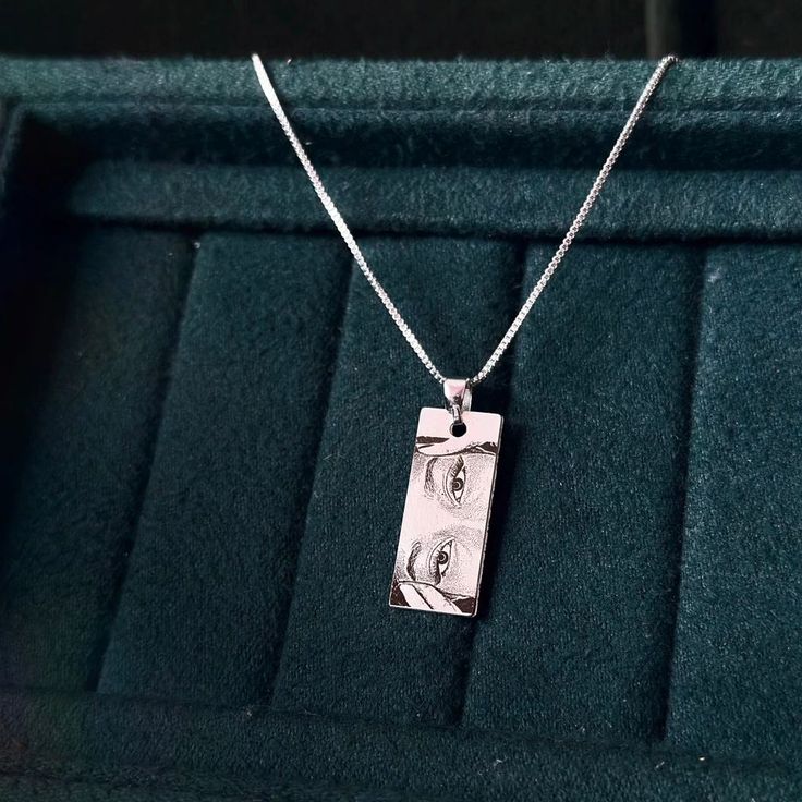 a silver necklace with two birds on it in a velvet box that is open to show the jewelry inside