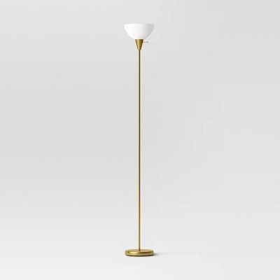 the floor lamp is gold and has a white shade on it's top half