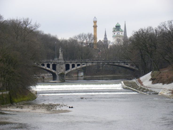 a bridge over a body of water with trees in the background