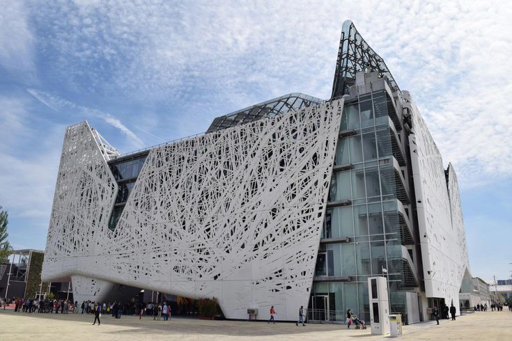 a large white building with people walking around it