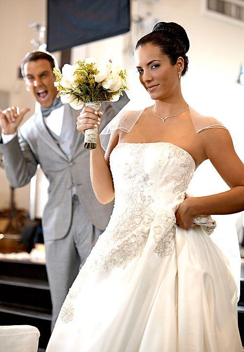 a man and woman in wedding attire standing next to each other with flowers on their bouquets