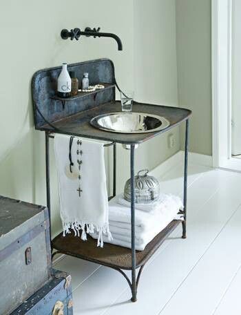 a bathroom with a sink, towel rack and suitcases