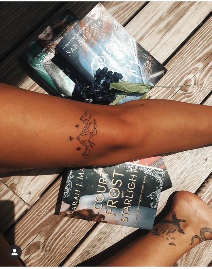 a person with a tattoo on their arm next to some books