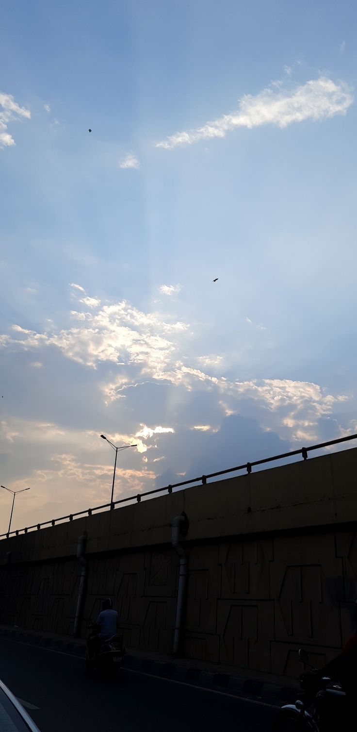 the sky is very cloudy and there are two people on motorcycles