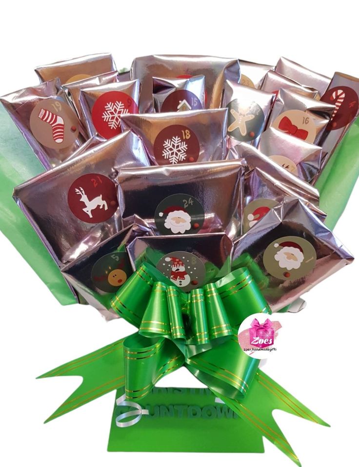 a bouquet of assorted chocolates wrapped in foil with a green bow on top