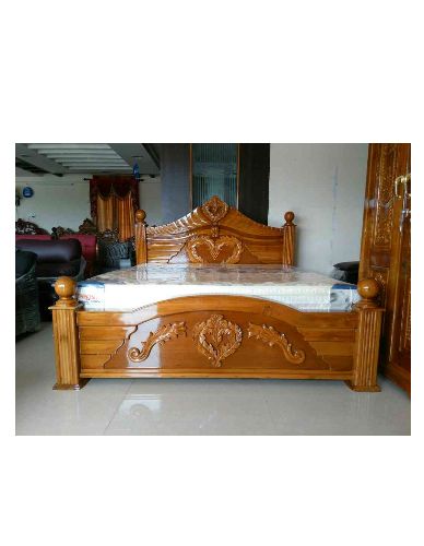 a wooden bed frame with carvings on the headboard and foot board in a room