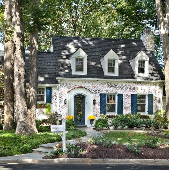 a brick house with blue shutters and white trim