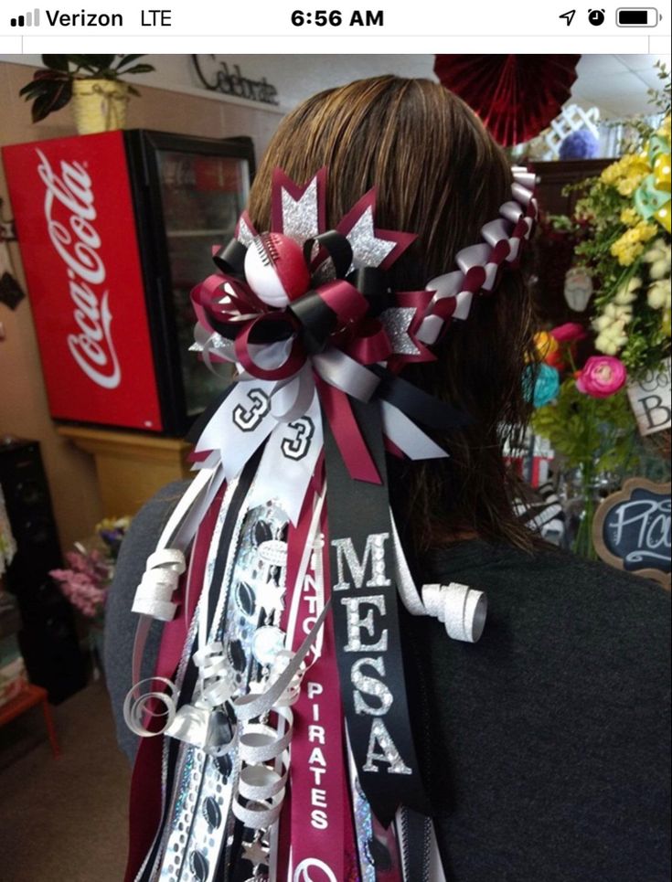 the back of a woman's head wearing a red, white and black hair bow