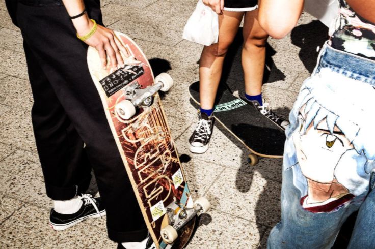 people standing around with their skateboards in hand