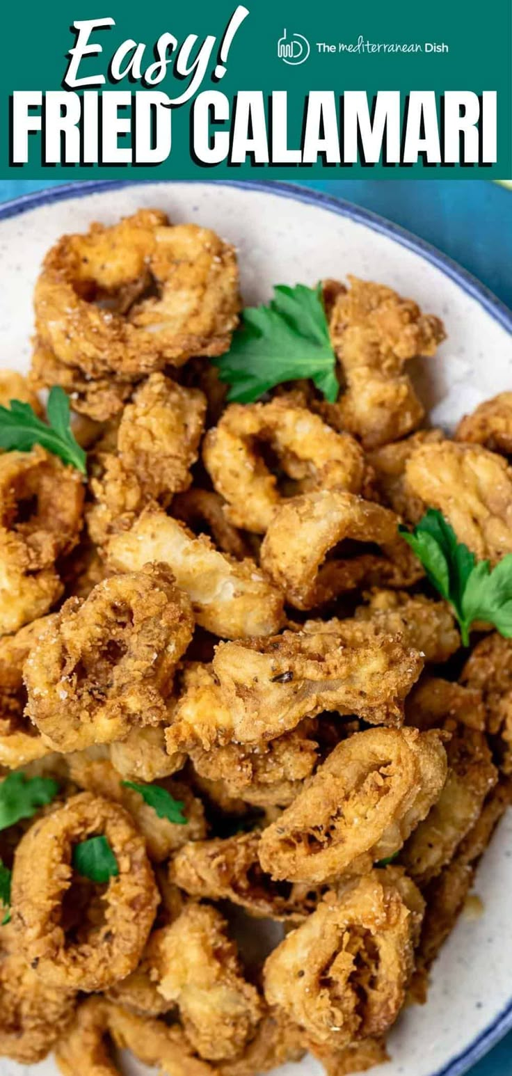 fried calamari on a white plate with basil leaves and text overlay that reads easy fried calamari